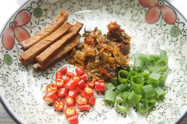 首先把葱,辣椒,豆干切一下,作为配菜,方便面里面的酸菜包取出也作为